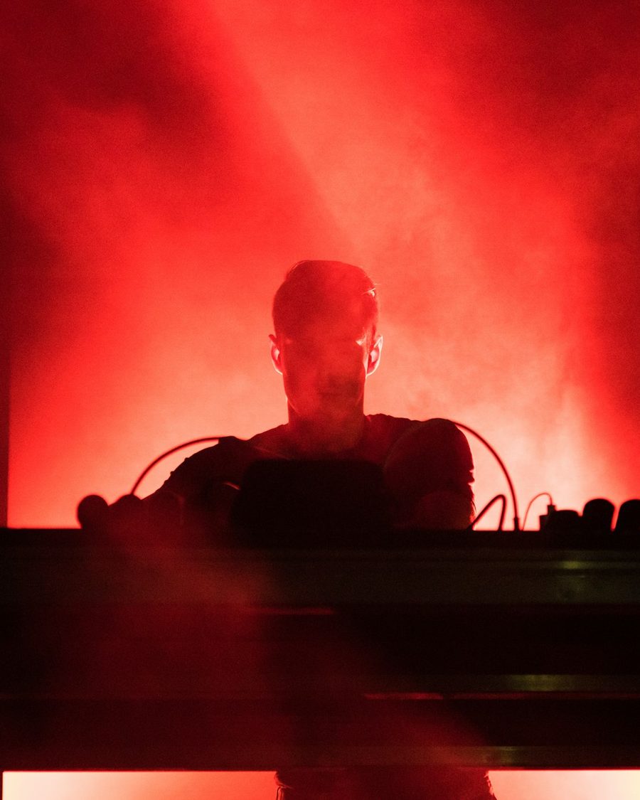 DJ na cabine sob luz de palco (imagem ilustrativa)